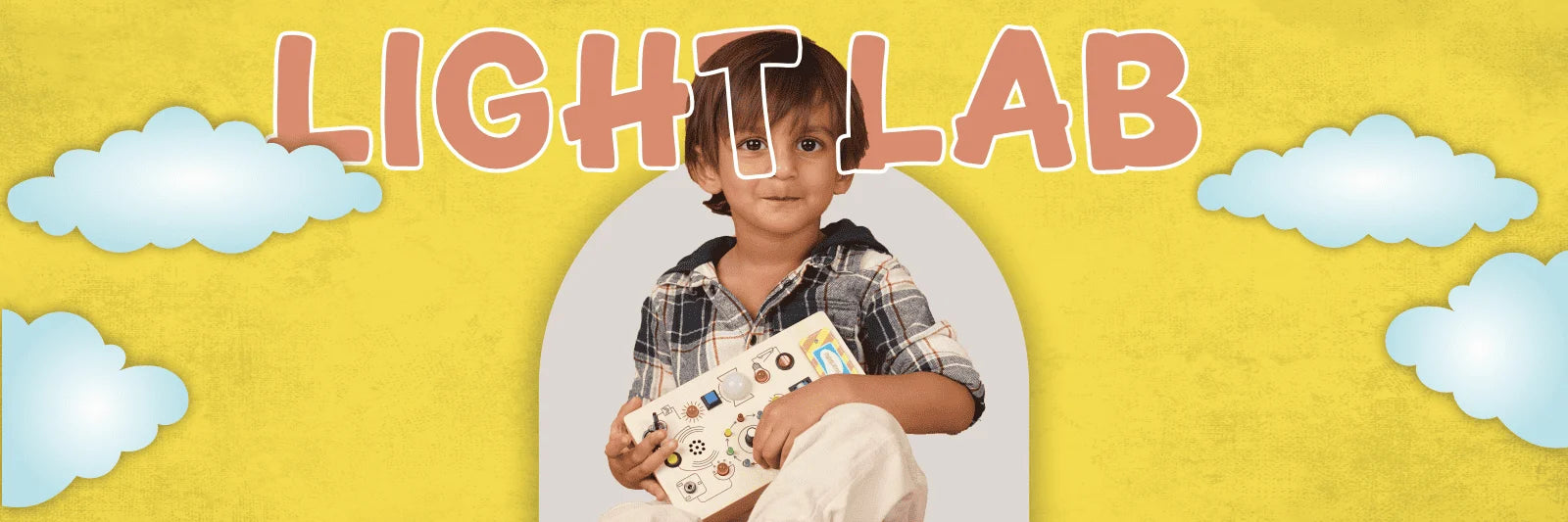 Child holding Light Lab activity board with lights and switches